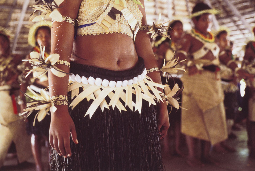 A view of a woman's torso. She is wearing a traditional clothing.