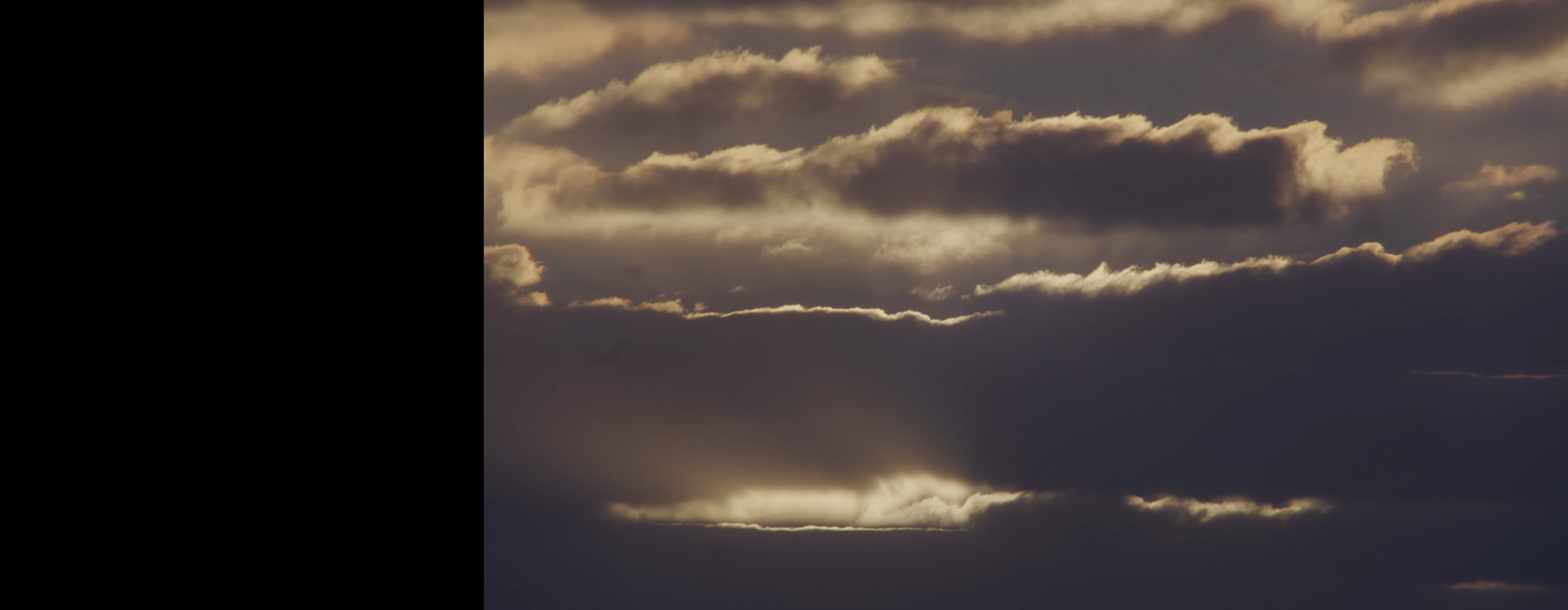 A moody cloudscape with clouds highlighted by light.