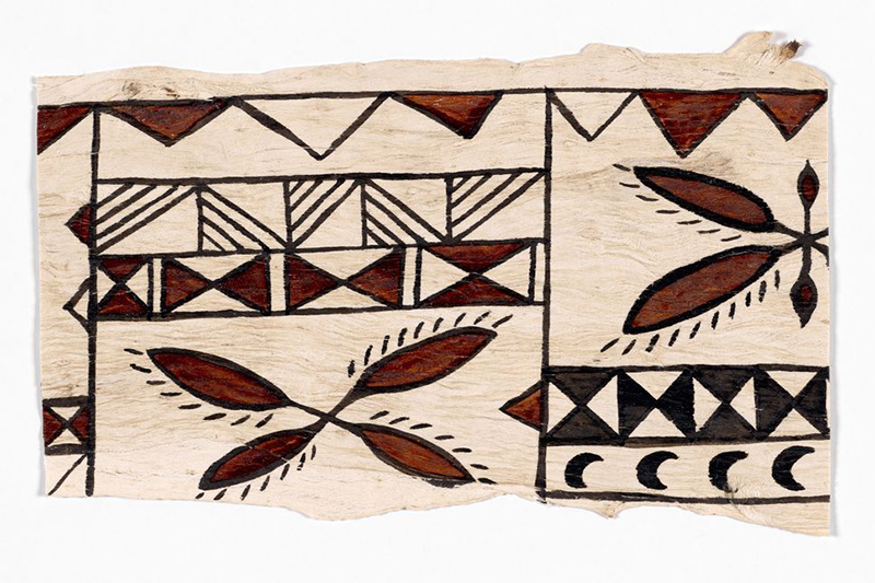 A piece of tapa bark cloth with brown and black patterns on it.