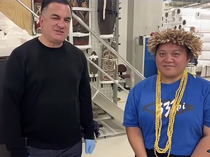 Still from livestream. Sean Mallon and PMN Niue host Inangaro Vakaafi. Two people are in a store room and looking at the camera.