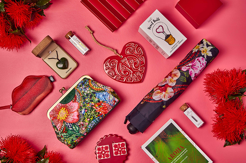 A photo of several objects that are either red or heart-shaped, or lip-shaped all laid out neatly on a pink background.