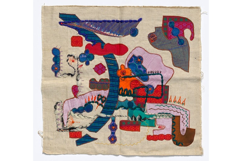 A piece of beige cotton material with different coloured pieces of material stitched onto it.