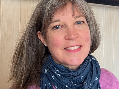 Photo courtesy of author Head and shoulders shot of a woman who is wearing a pink shirt and patterned scarf