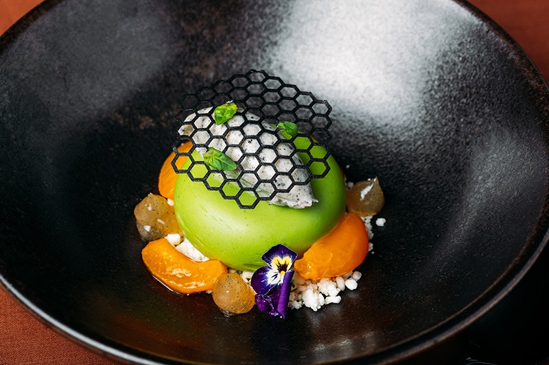 A dessert in a large dark bowl.