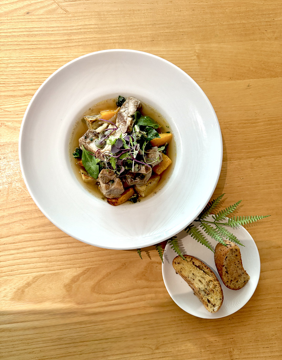 A top-down view of a large plate with a stew in the centre, and