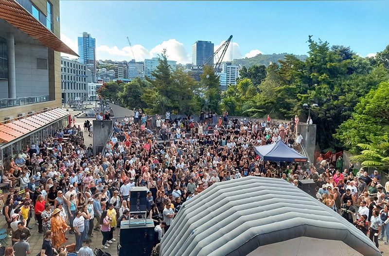 A large crowd in front of an inflatable stage outside.