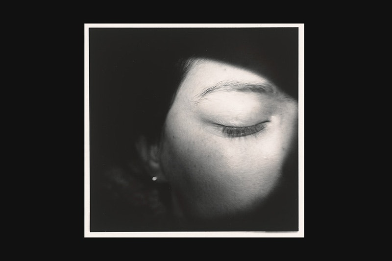 A black banner with a photo on the right-hand side of a close up on a woman's face with her eye closed.