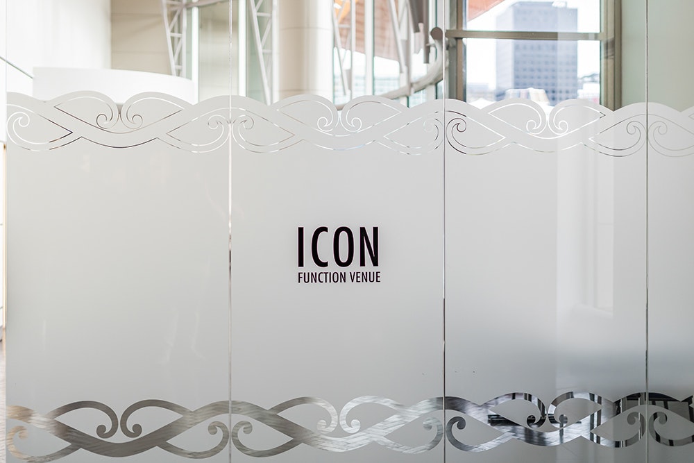 An image of a glass door with frosted window and the words Icon Function Venue etched into it.
