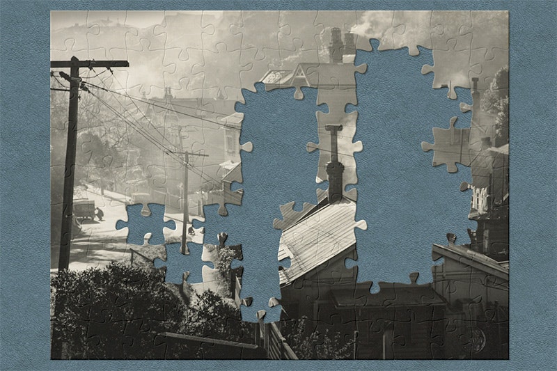 A black and white photograph on a teal background with jigsaw shapes missing.