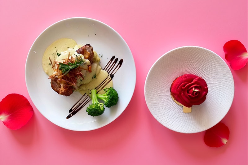 A top-down view of two plates of food. One has a savoury course and one has a dessert.