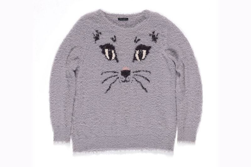 A grey jersey with the face of a cat with whiskers knitted into it.