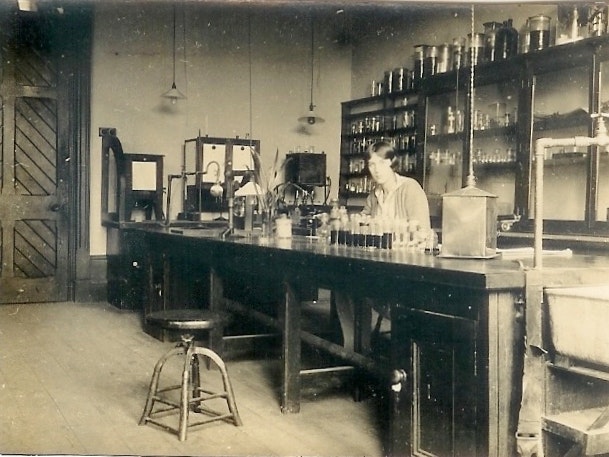 Dominion Museum Staff; 1930s; maker unknown. Te Papa (CA001026/001/0001/0004) An old photo of a woman in a laboratory in a museum.
